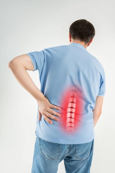 Lumbar intervertebral spine hernia, man with back ache suffers from pain, spinal disc disease, painful area highlighted in red
